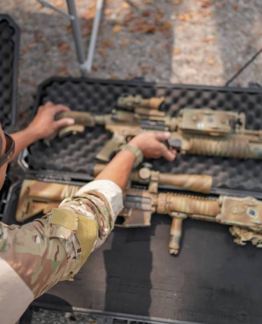 Army soldier shooting with firearm in battlefield. United States Army ranger during the military operation. Professional marine soldiers training with weapon on a military range.
